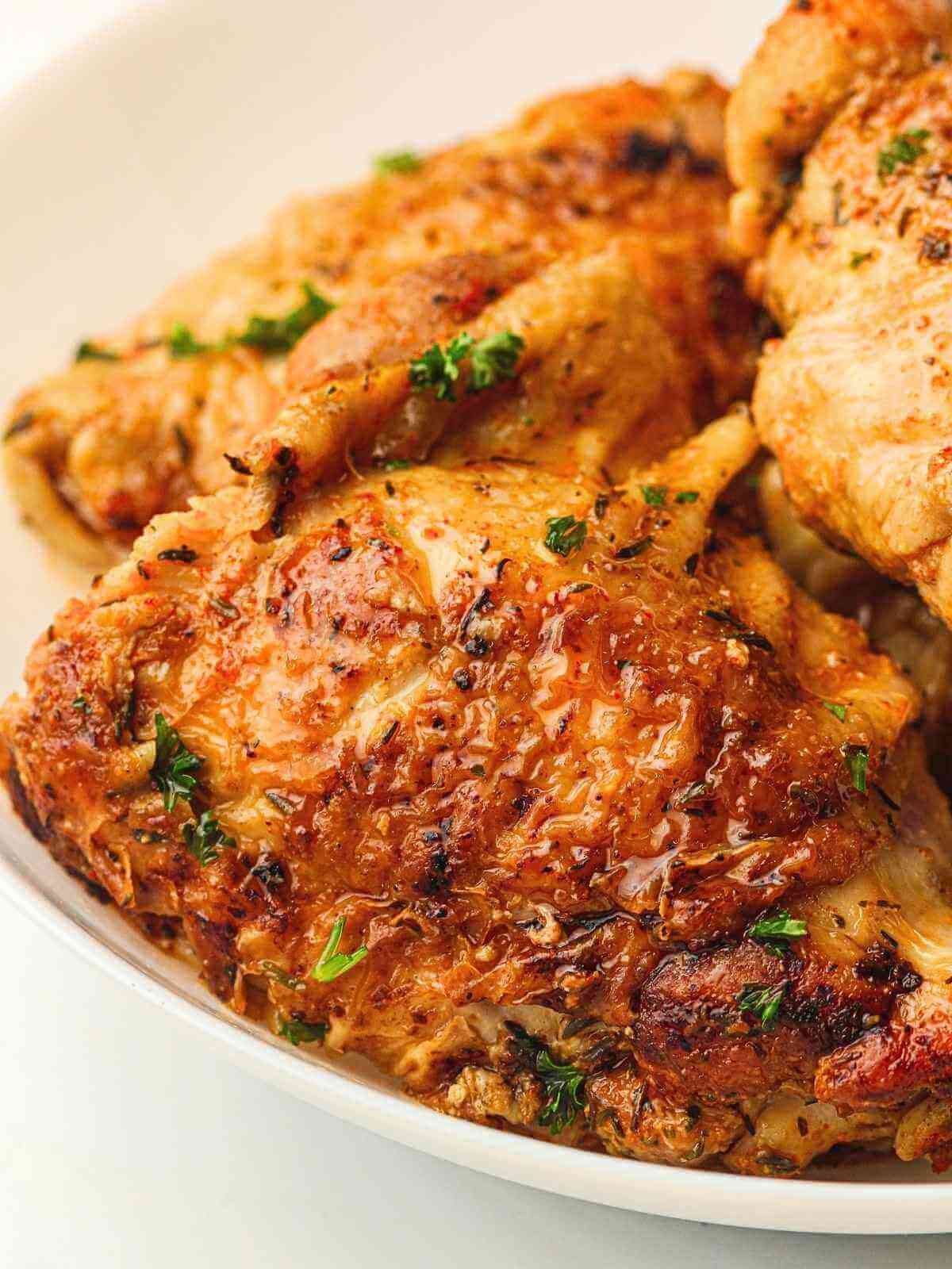 Chicken thighs in the instant pot with parsley garnish.
