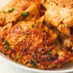 Instant pot chicken thighs in a white dinner plate.