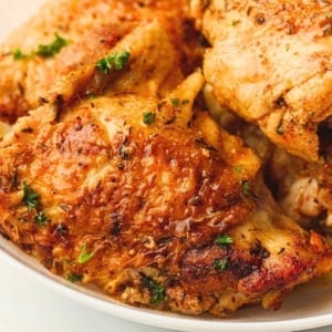 Instant pot chicken thighs in a white dinner plate.