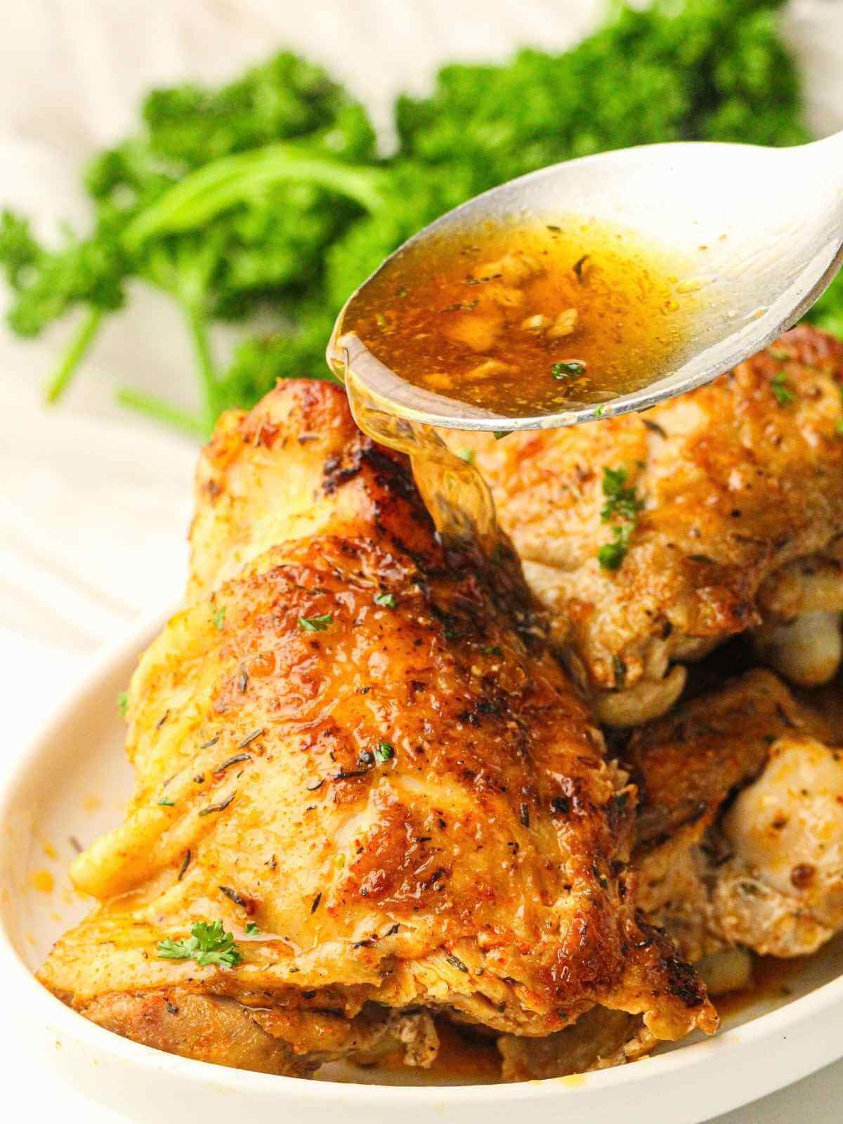 Drizzling the gravy over the chicken thighs.